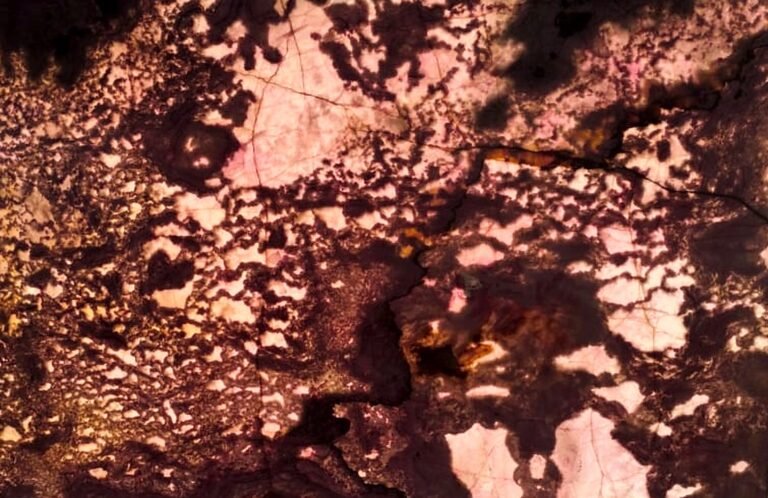 Backlit Exotic Pink Onyx slab glowing white, soft pink and warm amber through deep maroon veins